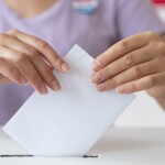 person-placing-its-vote-box